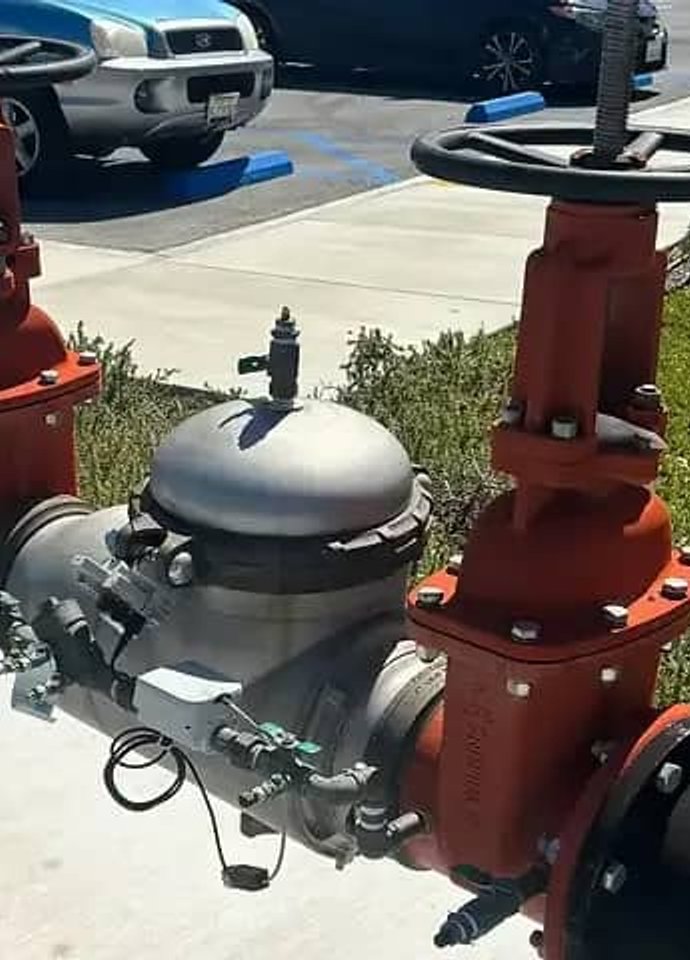 Red backflow assemblies installed outdoors